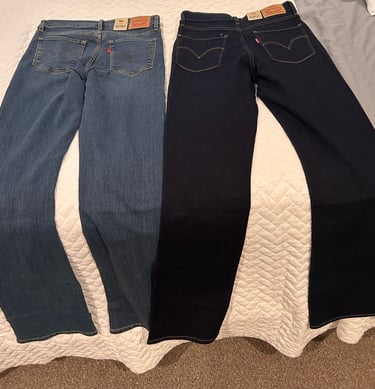 Two pairs of Levi’s 315 Shaping Bootcut jeans laid side by side on a bed — medium wash and dark wash