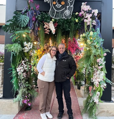 David Helberg with his wife (Amy) standing, surrounded by flowers
