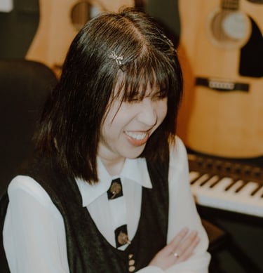 Ritchell Lim smiling with a guitar and keyboard in the background