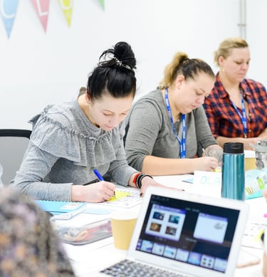 3 ladies taking notes at a desk