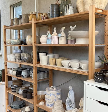 a shelf with many different types of potteryware