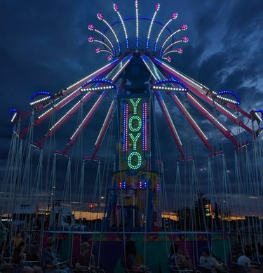 a carnival ride at night with people sitting on chairs