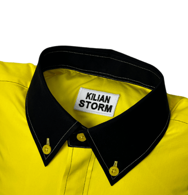 a yellow shirted pillow with a black collar and label