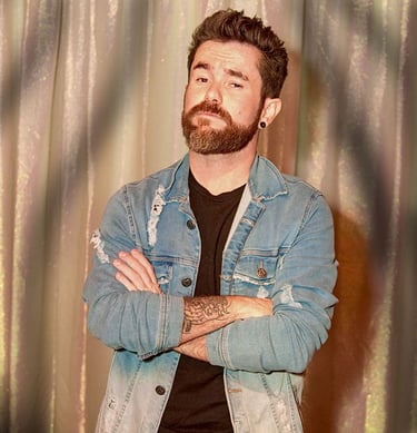 Singer Leo Couto wearing a light denim jacket over a black t-shirt.