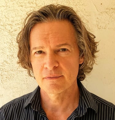 Todd Long with medium-length hair and serious expression