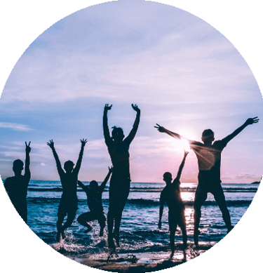 people on the beach facing the sea and the sun rising
