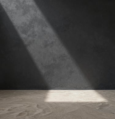Interior architectural space, wide shot, ray of light hitting a textured charcoal wall, soft sand floor, zen-like peace #F9F7F2 #333333