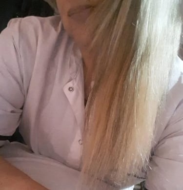 Retrato de Ariadna vistiendo chaqueta blanca profesional en su espacio de masajes en Almagro.