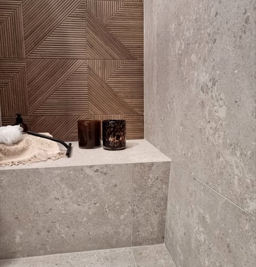Modern bathroom shower featuring gray terrazzo wall tiles and a brown geometric wood-look accent wall.