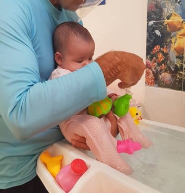 a man holding a baby in a bathtub