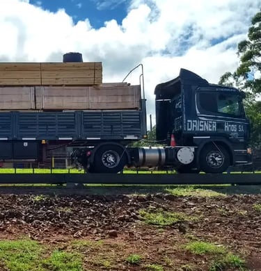 A black semi-truck transporting stacks of lumber.
