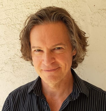 Headshot of Todd Long smiling with medium-length hair