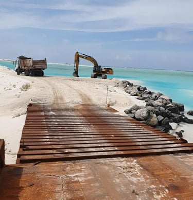 a construction worker is working on a beach with rock boulders in Maldives