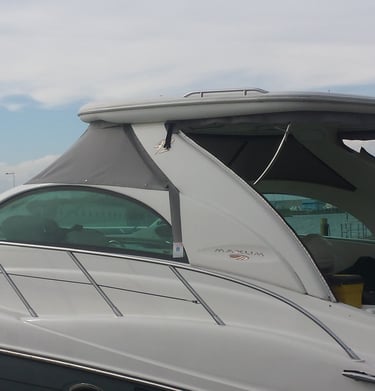 Side view of a white Maxum luxury motor yacht docked at a marina under a cloudy sky.