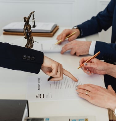 Couple signing divorce papers in a lawyers office dissolving their marriage