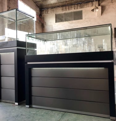 Modern black jewelry display cases with LED lighting and glass showcases in a retail furniture warehouse.