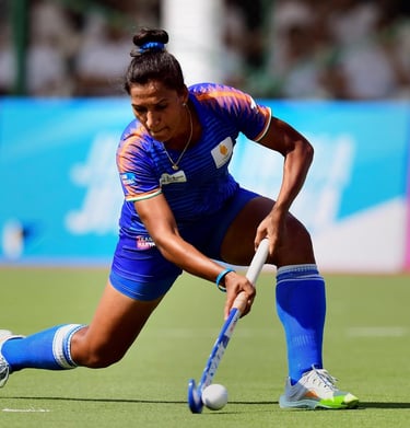 Rani Rampal taking a powerful hockey shot on the field.