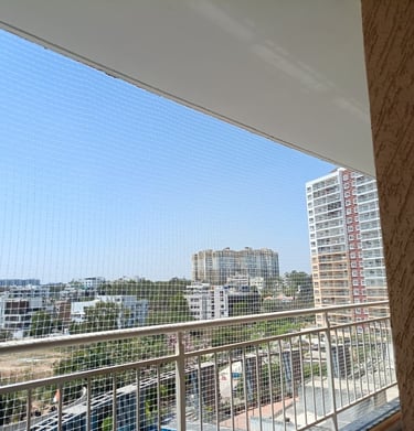 Aerial perspective highlighting multiple balconies equipped with safety nets across KR Puram neighbo