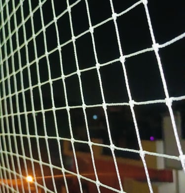 Technician from Sukumari Safety Nets carefully installing a net on a high-rise balcony.