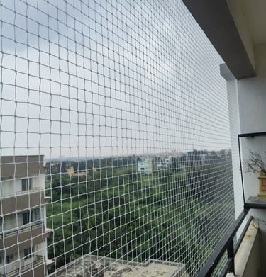  Wide angle view of a balcony fully enclosed with a durable safety net under bright daylight.   Ask