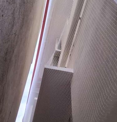 Technician carefully fitting a duct net in a narrow duct space, highlighting precision work.