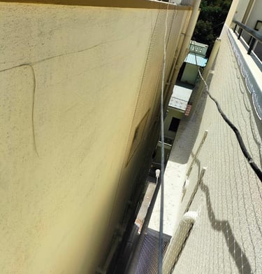 Panoramic shot of Haralur neighborhood showcasing several buildings with duct nets installed.