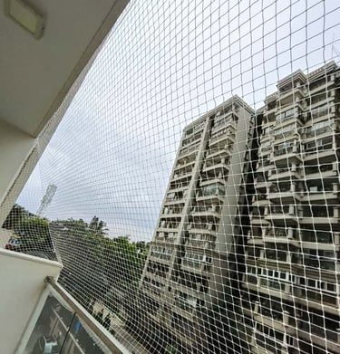 Installation team fitting a pigeon net on a window in Jayanagar, ensuring secure ventilation.