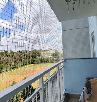 Technician carefully installing a balcony safety net with precision and care.