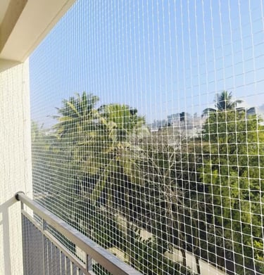 Technician from Arjilli Enterprises carefully measuring a balcony frame before net installation.