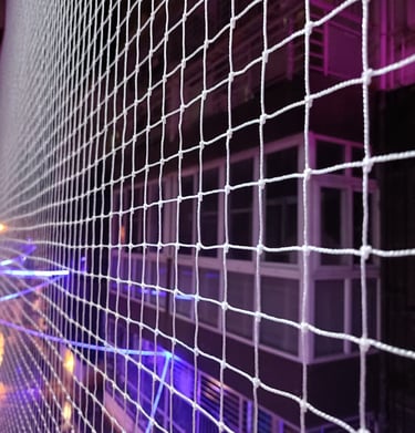 A balcony corner wrapped with pigeon netting, blending seamlessly with the building’s exterior.