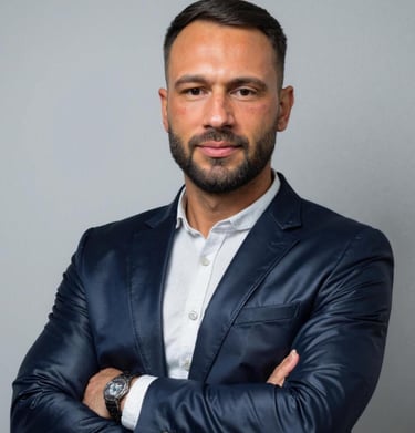 Professional businessman with a beard wearing a navy blue blazer and white shirt.