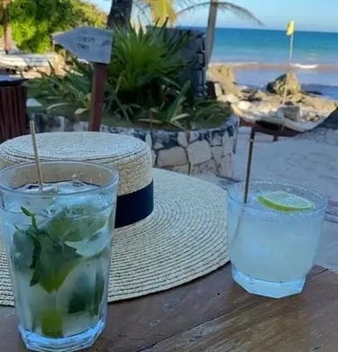 two glasses of water and a straw hat on a table