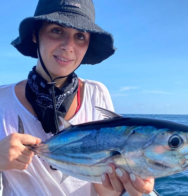 Girl proudly showing her caught fish on a catamaran - Catamaran Fishing Charters Seychelles