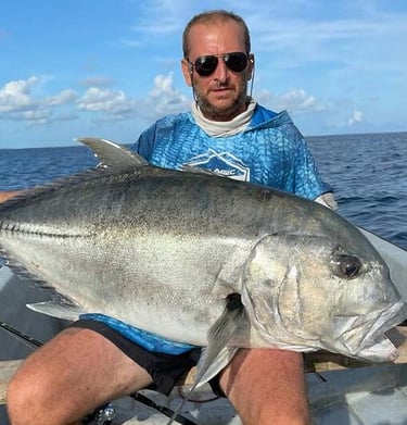 Angler holding a Giant Trevally after a successful Half-Day Fishing Charter in Zanzibar