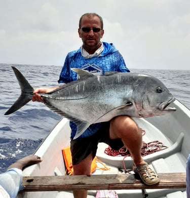 Angler holding a giant trevally on a Catamaran Fishing Charter in Zanzibar