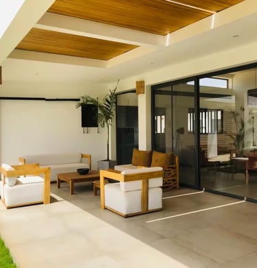 a patio with a couch and chairs and a television