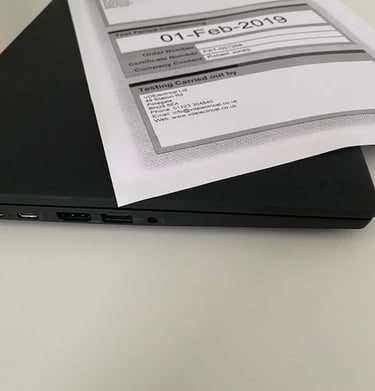 a laptop computer sitting on a desk with a paper document