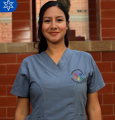 a woman in scrubs and scrubs standing in front of a brick wall