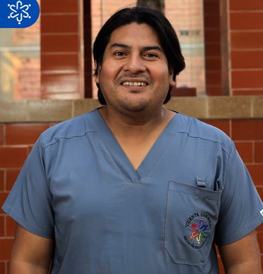 a man in scrubies and scrubies standing in front of a brick wall