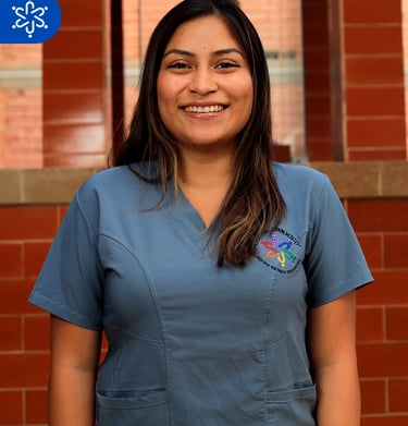 a woman in scrubs and scrubs standing in front of a brick wall