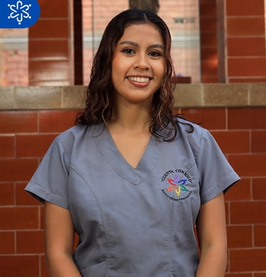 a woman in scrubs and scrubs standing in front of a brick wall