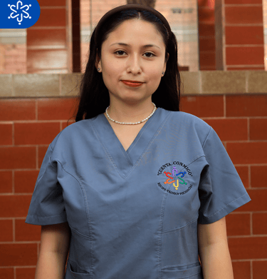 a woman in scrubs and scrubs standing in front of a brick wall