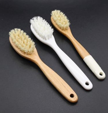 Artisan hands carefully packaging natural wooden brushes in eco-friendly boxes.