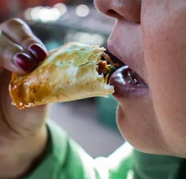 Persona disfrutando taco de barbacoa recién preparado en Querétaro.