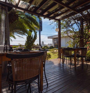  Área externa coberta do Kaizen com bar e mesas em madeira