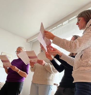 eine Gruppe von Sängern bei der Chorprobe mit Notenblättern in der Hand