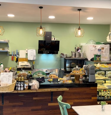 içi yumuşak yeşil tonunda boyanmış, doğal ışıkla aydınlanmış kafe 