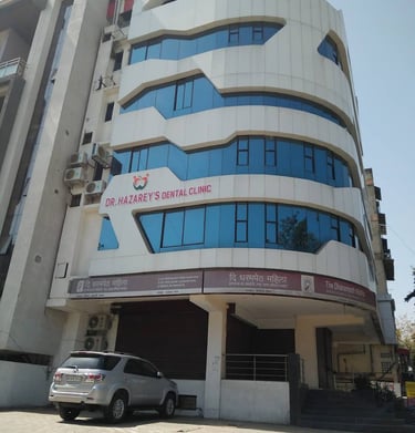 Modern architecture of Dr. Hazarey's Dental Clinic in Nagpur with blue glass windows.