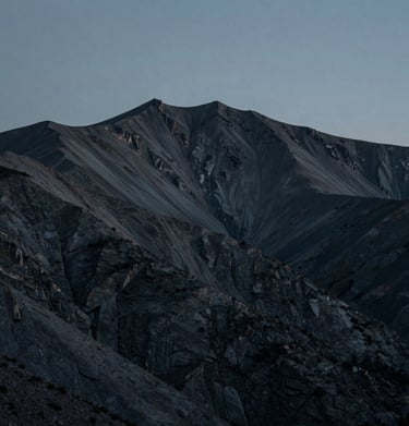 A minimalist North American / US mountain landscape at dusk, dark slate and teal gray tones, sophisticated and calm atmosphere, professional nature photography.