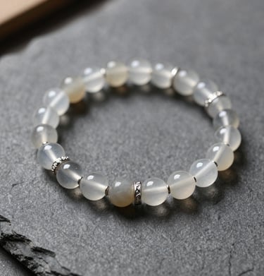 Elegant moonstone beaded bracelet with silver spacers on a dark slate background.